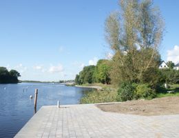 Im Vordergrund der Eider bei Stapel ist eine befestigte Anlegestelle für größere Boote zu sehen.